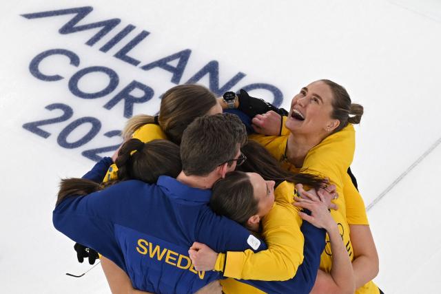 Sweden's Anna Hasselborg, Sweden's Sara McManus, Sweden's Agnes Knochenhauer and Sweden's Sofia Scharback celebrate with their teammates after winning the curling women's round robin semi-final between Canada and Sweden during the Milano Cortina 2026 Winter Olympic Games at the Cortina Curling Olympic Stadium in Cortina d’Ampezzo on February 20, 2026. (Photo by Antonin THUILLIER / AFP)
