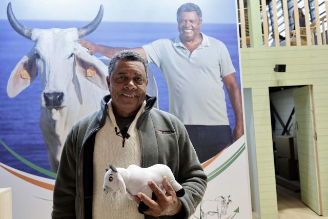 French Brahman cattle breeder from Martinique Andre Prosper poses for a photograph at the stand that was supposed to host his cow named Biguine who was chosen to be the mascot for the 2026 edition of the International Agricultural Show (Salon de l'Agriculture) at Paris Expo Porte de Versailles in Paris on February 20, 2026. Cattle breed selection organisations decided not to enter any cattle in the general agricultural competition at this show and refused to allow any cows to be present, including Biguine, due to the lumpy skin epizootic disease (dermatose nodulaire contagieuse). (Photo by STEPHANE DE SAKUTIN / AFP)