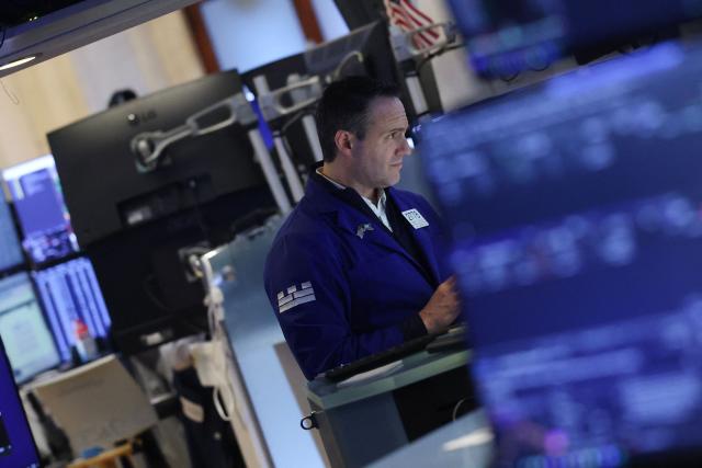 A trader works on the floor of the New York Stock Exchange (NYSE) at the opening bell in New York, on February 20, 2026. Wall Street stocks mostly fell early Friday following data showing disappointing US economic growth and an uptick in inflation. (Photo by TIMOTHY A. CLARY / AFP)