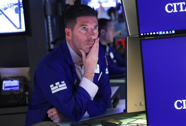 A trader works on the floor of the New York Stock Exchange (NYSE) at the opening bell in New York, on February 20, 2026. Wall Street stocks mostly fell early Friday following data showing disappointing US economic growth and an uptick in inflation. (Photo by TIMOTHY A. CLARY / AFP)