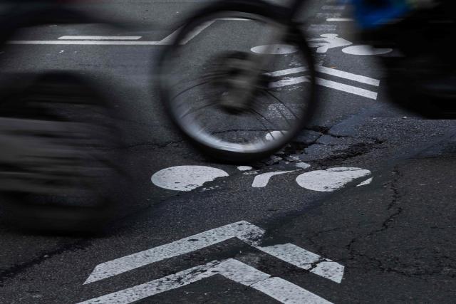 A motorcyclist rides over a pothole on a cycle path in central Paris on February 20, 2026. (Photo by JOEL SAGET / AFP)