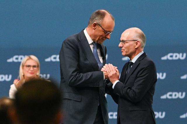 German Chancellor and Chairman of the Christian Democratic Party (CDU) Friedrich Merz (L), greets Luxembourg’s prime minister Luc Frieden after his speech at the CDU party Congress at the fair grounds in Stuttgart, southern Germany, on February 20, 2026. (Photo by THOMAS KIENZLE / AFP)