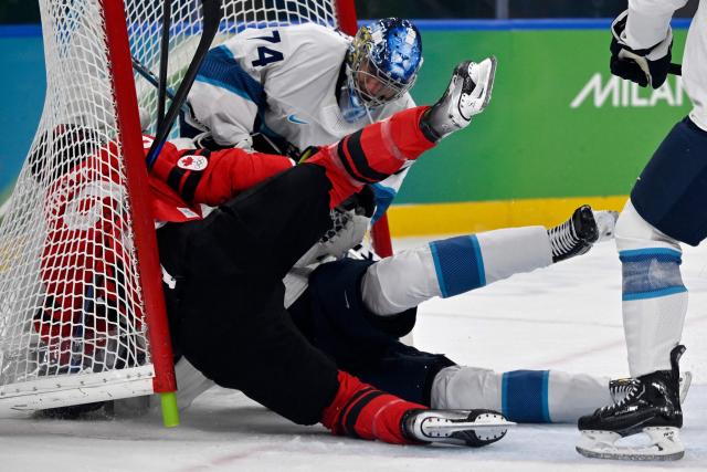 (LtoR) Canada's #09 Sam Bennett, Finland's #77 Niko Mikkola and Finland's #74 Juuse Saros dislodge the goal during the men's play-off semi-final ice hockey match between Canada and Finland at the Milano Santagiulia Ice Hockey Arena during the Milano Cortina 2026 Winter Olympic Games in Milan, on February 20, 2026. (Photo by Alexander NEMENOV / AFP)
