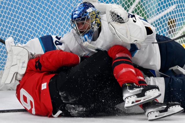 (LtoR) Canada's #09 Sam Bennett and Finland's #74 Juuse Saros react as they dislodge the goal during the men's play-off semi-final ice hockey match between Canada and Finland at the Milano Santagiulia Ice Hockey Arena during the Milano Cortina 2026 Winter Olympic Games in Milan, on February 20, 2026. (Photo by Alexander NEMENOV / AFP)