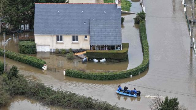 Aerial view of French gendarmes in a boat on a street flooded by the Sarthe river in Cheffes, western France, on February 20, 2026. (Photo by Damien MEYER / AFP)