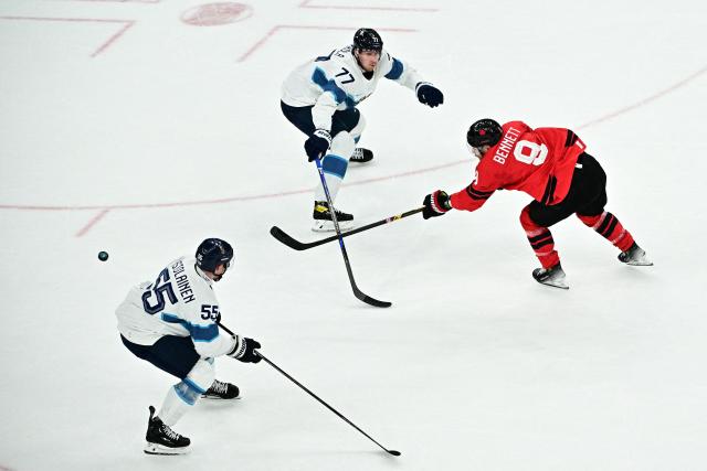 Canada's #09 Sam Bennett (R) shoots the puck past Finland's #55 Rasmus Ristolainen (L) and Finland's #77 Niko Mikkola (C) during the men's play-off semi-final ice hockey match between Canada and Finland at the Milano Santagiulia Ice Hockey Arena during the Milano Cortina 2026 Winter Olympic Games in Milan, on February 20, 2026. (Photo by JULIEN DE ROSA / AFP)
