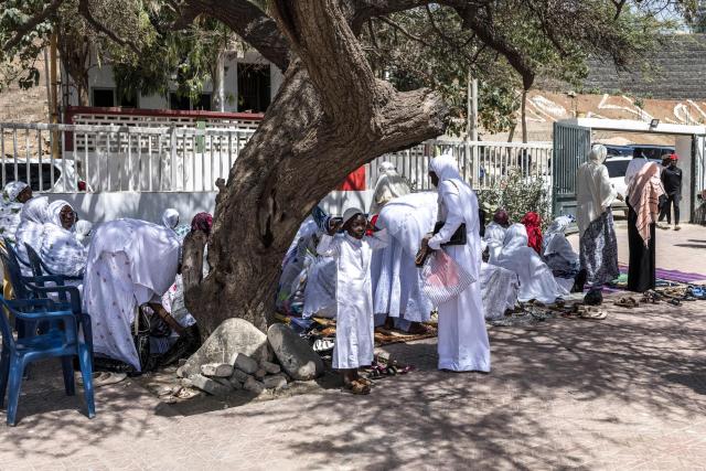 A girl adjusts her underscarf ahead of the first Friday prayer of the holy month of Ramadan at the Mosque of the Divinity in Dakar, on February 20, 2026. (Photo by PATRICK MEINHARDT / AFP)