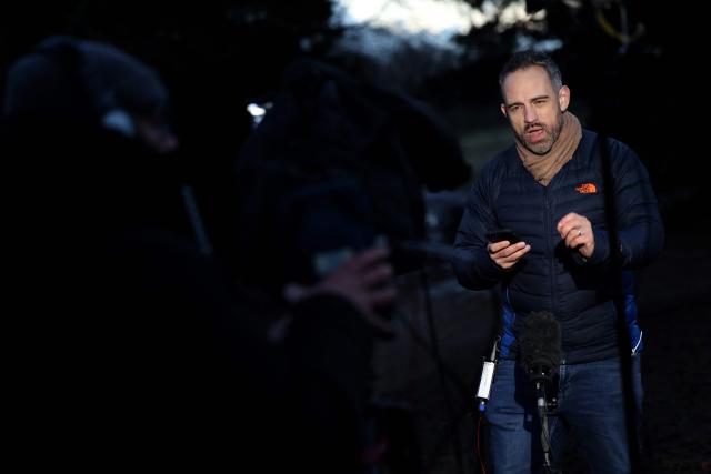 A member of the media talks to camera near to an entrance to Wood Farm on the royal family's Sandringham Estate in Norfolk, eastern England on February 20, 2026, the day after Britain's former prince Andrew was arrested. Britain's royal family was thrown into crisis on February 19 after former prince Andrew was arrested by police and held for hours, in a blow to the monarchy unprecedented in modern British history. (Photo by Toby Shepheard / AFP)