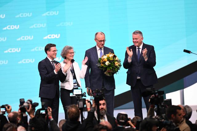 German Chancellor and Chairman of the Christian Democratic Party (CDU) Friedrich Merz (3rd R), receives flowers after he was re-elected as party Chairman at the CDU party Congress at the fair grounds in Stuttgart, southern Germany, on February 20, 2026. (Photo by THOMAS KIENZLE / AFP)