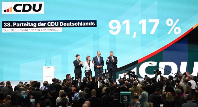 German Chancellor and Chairman of the Christian Democratic Party (CDU) Friedrich Merz (3rd R), reacts after he was re-elected as party Chairman at the CDU party Congress at the fair grounds in Stuttgart, southern Germany, on February 20, 2026. (Photo by THOMAS KIENZLE / AFP)