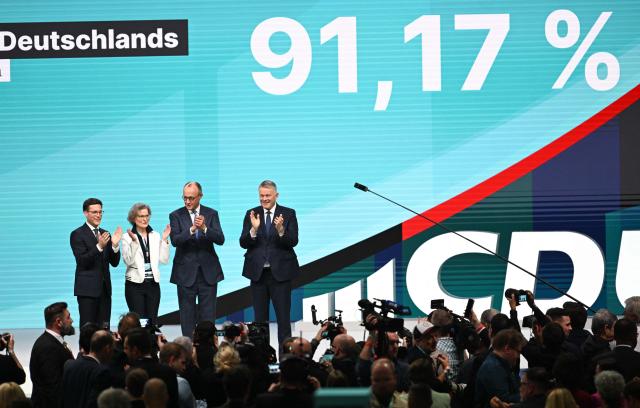 German Chancellor and Chairman of the Christian Democratic Party (CDU) Friedrich Merz (3rd R), reacts after he was re-elected as party Chairman at the CDU party Congress at the fair grounds in Stuttgart, southern Germany, on February 20, 2026. (Photo by THOMAS KIENZLE / AFP)