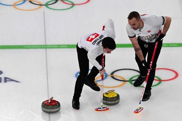 Switzerland's Benoit Schwarz-Van Berkel and Switzerland's Sven Michel compete in the curling men's round robin bronze medal game between Norway and Switzerland during the Milano Cortina 2026 Winter Olympic Games at the Cortina Curling Olympic Stadium in Cortina d’Ampezzo on February 20, 2026. (Photo by Stefano RELLANDINI / AFP)