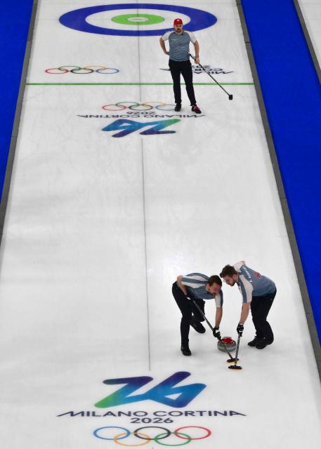 Norway's Martin Sesaker watches as Norway's Gaute Nepstad and Norway's Bendik Ramsfjell sweep in the curling men's round robin bronze medal game between Norway and Switzerland during the Milano Cortina 2026 Winter Olympic Games at the Cortina Curling Olympic Stadium in Cortina d’Ampezzo on February 20, 2026. (Photo by Stefano RELLANDINI / AFP)