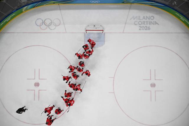 Canada players celebrate winning the men's play-off semi-final ice hockey match between Canada and Finland at the Milano Santagiulia Ice Hockey Arena during the Milano Cortina 2026 Winter Olympic Games in Milan, on February 20, 2026. Canada won 3-2. (Photo by JULIEN DE ROSA / AFP)