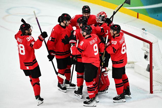 Canada's players celebrate after winning the men's play-off semi-final ice hockey match between Canada and Finland at the Milano Santagiulia Ice Hockey Arena during the Milano Cortina 2026 Winter Olympic Games in Milan, on February 20, 2026. (Photo by JULIEN DE ROSA / AFP)