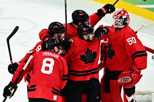 Canada's players celebrate after winning the men's play-off semi-final ice hockey match between Canada and Finland at the Milano Santagiulia Ice Hockey Arena during the Milano Cortina 2026 Winter Olympic Games in Milan, on February 20, 2026. (Photo by JULIEN DE ROSA / AFP)