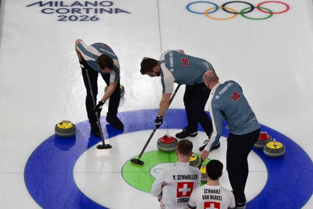 Switzerland's Yannick Schwaller and Switzerland's Benoit Schwarz-Van Berkel watches as Norway's Gaute Nepstad, Norway's Bendik Ramsfjell and Norway's Magnus Ramsfjell sweep in the curling men's round robin bronze medal game between Norway and Switzerland during the Milano Cortina 2026 Winter Olympic Games at the Cortina Curling Olympic Stadium in Cortina d’Ampezzo on February 20, 2026. (Photo by Stefano RELLANDINI / AFP)