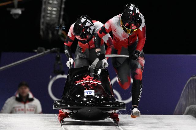 Canada's Bianca Ribi and Canada's Skylar Sieben compete in the women's bobsleigh 2-woman heat 2 at Cortina Sliding Centre during the Milano Cortina 2026 Winter Olympic Games in Cortina d'Ampezzo on February 20, 2026. (Photo by Tiziana FABI / AFP)