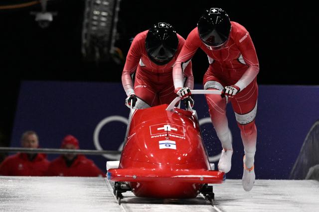 Switzerland's Debora Annen and Switzerland's Salome Kora compete in the women's bobsleigh 2-woman heat 2 at Cortina Sliding Centre during the Milano Cortina 2026 Winter Olympic Games in Cortina d'Ampezzo on February 20, 2026. (Photo by Tiziana FABI / AFP)