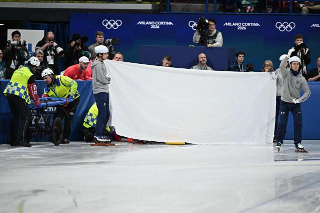 A sheet is held up as Poland's Kamila Sellier receives medical attention after crashing during the short track speed skating women's 1500m quarter-final during the Milano Cortina 2026 Winter Olympic Games at Milano Ice Skating Arena in Milan on February 20, 2026. (Photo by Gabriel BOUYS / AFP)