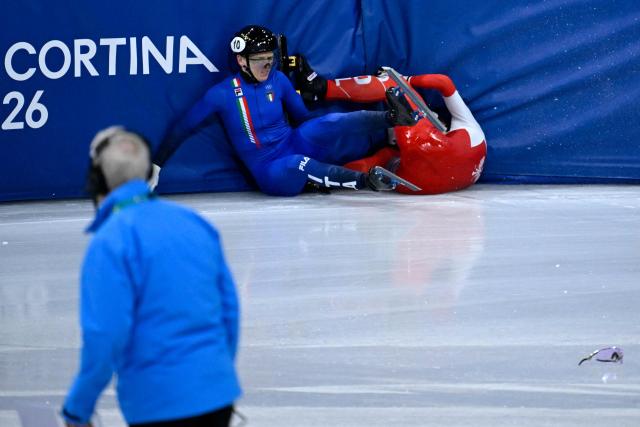 Italy's Arianna Fontana (L) and Poland's Kamila Sellier fall while competing in the short track speed skating women's 1500m quarter-final during the Milano Cortina 2026 Winter Olympic Games at Milano Ice Skating Arena in Milan on February 20, 2026. (Photo by WANG Zhao / AFP)