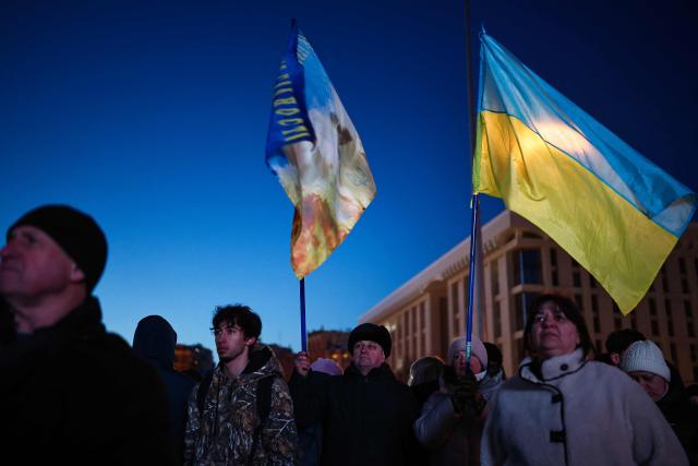 People gather at Independence Square for a "Heavenly Hundred" event commemorating those killed during the mass Euromaidan protests to mark the 12th anniversary of the uprising in Ukraine, on February 20, 2026, amid the Russian invasion of Ukraine. (Photo by HENRY NICHOLLS / AFP)