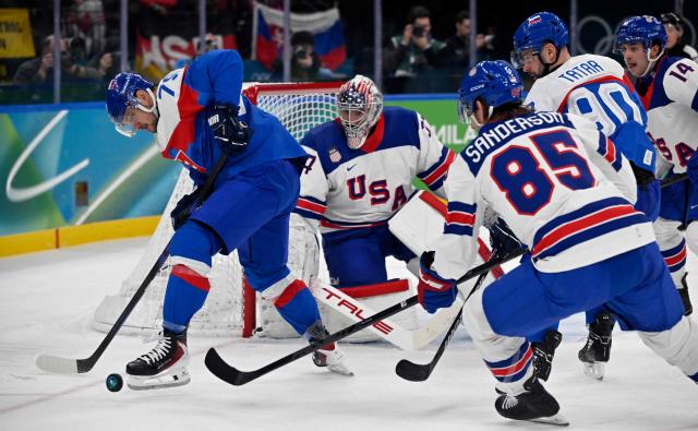 Slovakia's #79 Libor Hudacek (L) controls the puck during the men's play-off semi-final ice hockey match between USA and Slovakia at the Milano Santagiulia Ice Hockey Arena during the Milano Cortina 2026 Winter Olympic Games in Milan, on February 20, 2026. (Photo by Alexander NEMENOV / AFP)