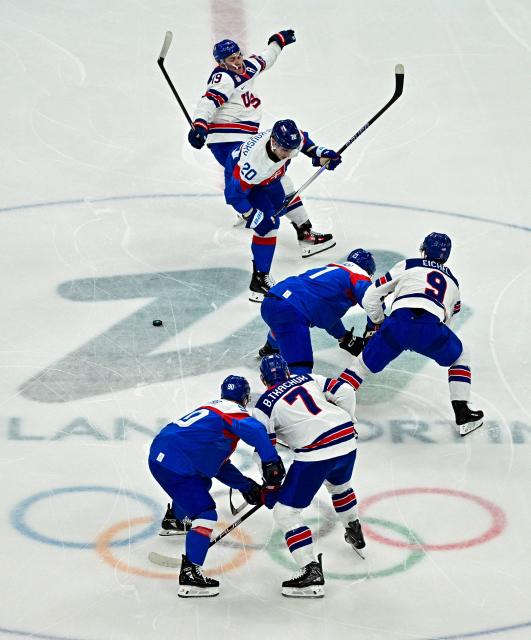 Slovakia's #21 Adam Ruzicka (C) Slovakia's #20 Juraj Slafkovsky and USA's #19 Matthew Tkachuk vie for the puck during the men's play-off semi-final ice hockey match between USA and Slovakia at the Milano Santagiulia Ice Hockey Arena during the Milano Cortina 2026 Winter Olympic Games in Milan, on February 20, 2026. (Photo by JULIEN DE ROSA / AFP)