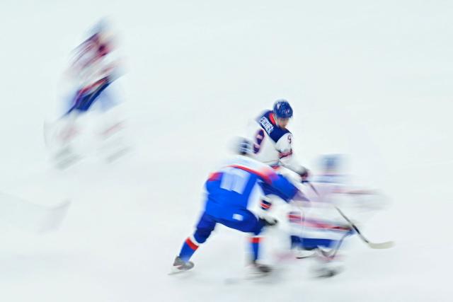 Players vie for the puck during the men's play-off semi-final ice hockey match between USA and Slovakia at the Milano Santagiulia Ice Hockey Arena during the Milano Cortina 2026 Winter Olympic Games in Milan, on February 20, 2026. (Photo by JULIEN DE ROSA / AFP)