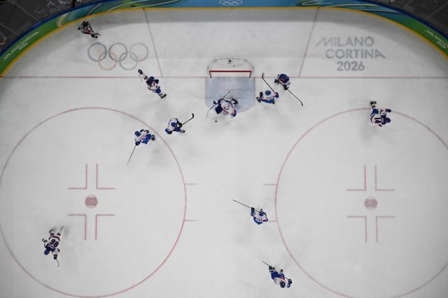 USA's #86 Jack Hughes (L) celebrates scoring a goal  during the men's play-off semi-final ice hockey match between USA and Slovakia at the Milano Santagiulia Ice Hockey Arena during the Milano Cortina 2026 Winter Olympic Games in Milan, on February 20, 2026. (Photo by JULIEN DE ROSA / POOL / AFP)