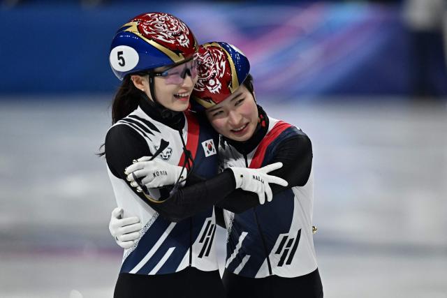 Gold medallist South Korea's Kim Gil-li (R) and silver medallist South Korea's Choi Min-jeong hug after the short track speed skating women's 1500m final during the Milano Cortina 2026 Winter Olympic Games at Milano Ice Skating Arena in Milan on February 20, 2026. (Photo by Gabriel BOUYS / AFP)