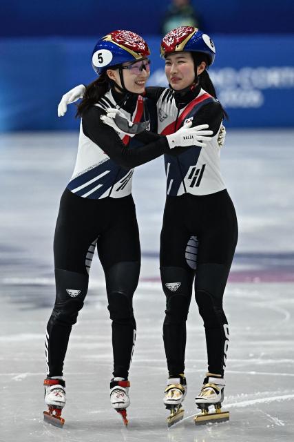 Gold medallist South Korea's Kim Gil-li (R) and silver medallist South Korea's Choi Min-jeong hug after the short track speed skating women's 1500m final during the Milano Cortina 2026 Winter Olympic Games at Milano Ice Skating Arena in Milan on February 20, 2026. (Photo by Gabriel BOUYS / AFP)