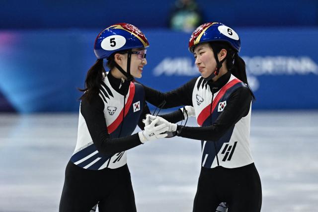 Gold medallist South Korea's Kim Gil-li (R) and silver medallist South Korea's Choi Min-jeong hug after the short track speed skating women's 1500m final during the Milano Cortina 2026 Winter Olympic Games at Milano Ice Skating Arena in Milan on February 20, 2026. (Photo by Gabriel BOUYS / AFP)