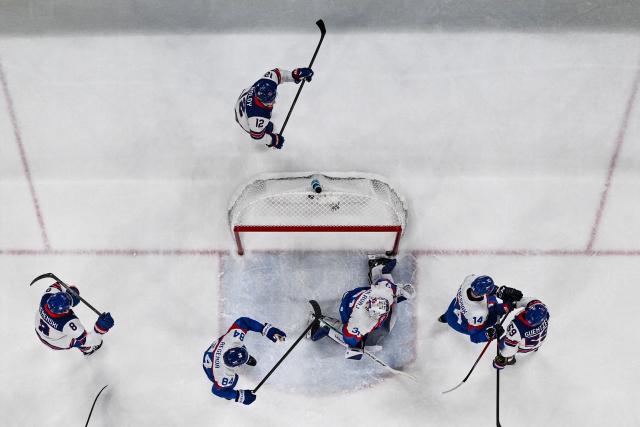 Slovakia's #31 Samuel Hlavaj (C) concedes a goal  during the men's play-off semi-final ice hockey match between USA and Slovakia at the Milano Santagiulia Ice Hockey Arena during the Milano Cortina 2026 Winter Olympic Games in Milan, on February 20, 2026. (Photo by JULIEN DE ROSA / POOL / AFP)