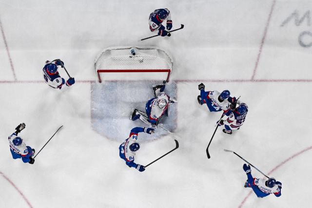 Slovakia's #31 Samuel Hlavaj (C) concedes a goal  during the men's play-off semi-final ice hockey match between USA and Slovakia at the Milano Santagiulia Ice Hockey Arena during the Milano Cortina 2026 Winter Olympic Games in Milan, on February 20, 2026. (Photo by JULIEN DE ROSA / POOL / AFP)