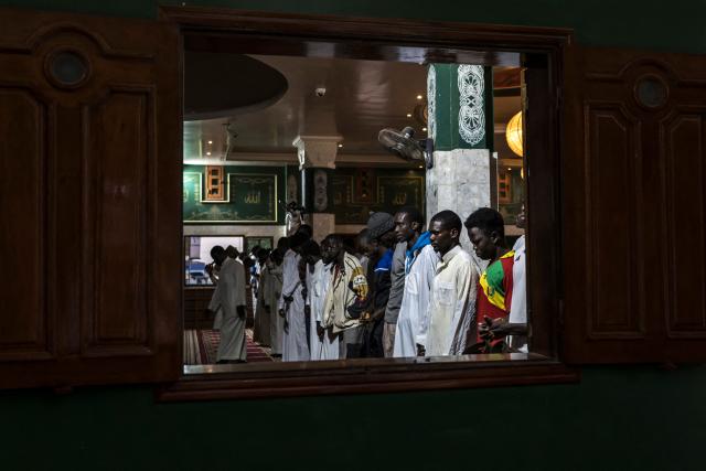 Muslims pray after breaking fast during the first Friday of the holy month of Ramadan at the Mosque of the Divinity in Dakar, on February 20, 2026. Muslims throughout the world are marking the month of Ramadan, the holiest month in the Islamic calendar, during which devotees fast from dawn until dusk. (Photo by PATRICK MEINHARDT / AFP)