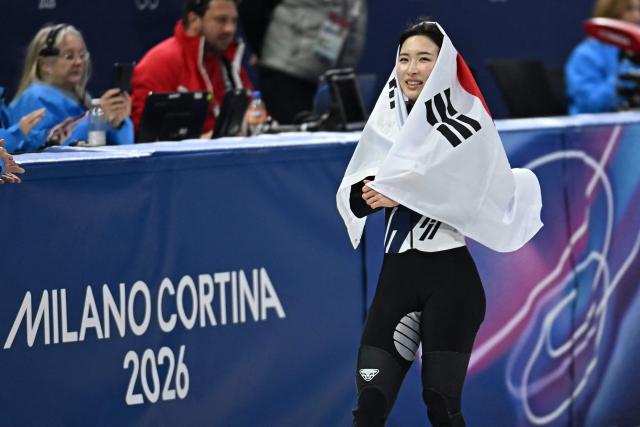 Gold medallist South Korea's Kim Gil-li celebrates with a flag of South Korea after the short track speed skating women's 1500m final during the Milano Cortina 2026 Winter Olympic Games at Milano Ice Skating Arena in Milan on February 20, 2026. (Photo by Gabriel BOUYS / AFP)