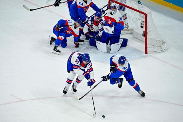 USA's #34 Auston Matthews (L) and Slovakia's #49 Samuel Takac vie for the puck during the men's play-off semi-final ice hockey match between USA and Slovakia at the Milano Santagiulia Ice Hockey Arena during the Milano Cortina 2026 Winter Olympic Games in Milan, on February 20, 2026. (Photo by JULIEN DE ROSA / AFP)
