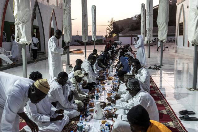 Muslims gather to break fast during the first Friday of the holy month of Ramadan at the Mosque of the Divinity in Dakar, on February 20, 2026. Muslims throughout the world are marking the month of Ramadan, the holiest month in the Islamic calendar, during which devotees fast from dawn until dusk. (Photo by PATRICK MEINHARDT / AFP)