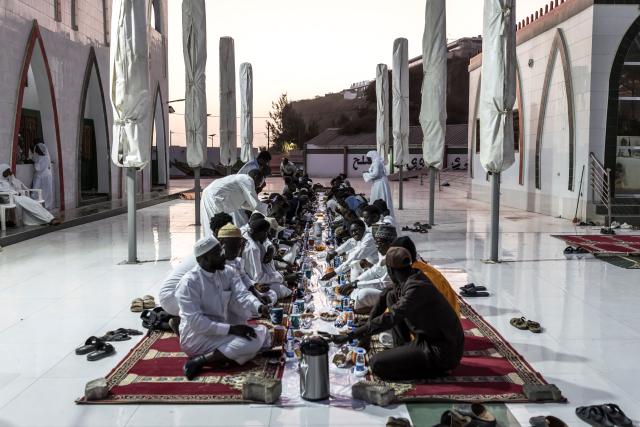 Muslims gather to break fast during the first Friday of the holy month of Ramadan at the Mosque of the Divinity in Dakar, on February 20, 2026. Muslims throughout the world are marking the month of Ramadan, the holiest month in the Islamic calendar, during which devotees fast from dawn until dusk. (Photo by PATRICK MEINHARDT / AFP)