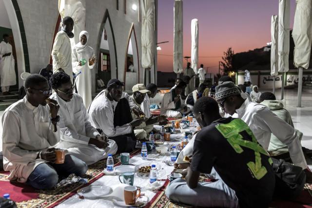 Muslims gather to break fast during the first Friday of the holy month of Ramadan at the Mosque of the Divinity in Dakar, on February 20, 2026. Muslims throughout the world are marking the month of Ramadan, the holiest month in the Islamic calendar, during which devotees fast from dawn until dusk. (Photo by PATRICK MEINHARDT / AFP)