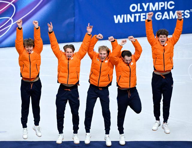 (From L) Gold medallists Netherlands' Melle van 't Wout, Netherlands' Jens van 't Wout, Netherlands' Friso Emons, Netherlands' Itzhak de Laat and Netherlands' Teun Boer jump as they arrive on the podium of the short track speed skating men's 5000m relay final during the Milano Cortina 2026 Winter Olympic Games at Milano Ice Skating Arena in Milan on February 20, 2026. (Photo by WANG Zhao / AFP)