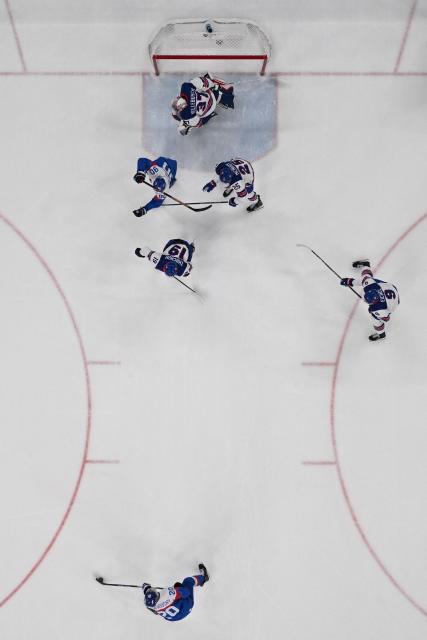 USA's #37 Connor Hellebuyck (up) concedes a goal by Slovakia's #20 Juraj Slafkovsky (down)  during the men's play-off semi-final ice hockey match between USA and Slovakia at the Milano Santagiulia Ice Hockey Arena during the Milano Cortina 2026 Winter Olympic Games in Milan, on February 20, 2026. (Photo by JULIEN DE ROSA / AFP)