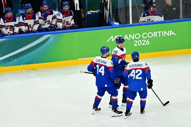 Slovakia's #20 Juraj Slafkovsky (C) celebrates after scoring their first goal during the men's play-off semi-final ice hockey match between USA and Slovakia at the Milano Santagiulia Ice Hockey Arena during the Milano Cortina 2026 Winter Olympic Games in Milan, on February 20, 2026. (Photo by JULIEN DE ROSA / AFP)