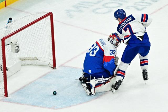 USA's #07 Brady Tkachuk (R) scores the 6-1 goal past Slovakia's #33 Stanislav Skorvanek during the men's play-off semi-final ice hockey match between USA and Slovakia at the Milano Santagiulia Ice Hockey Arena during the Milano Cortina 2026 Winter Olympic Games in Milan, on February 20, 2026. (Photo by JULIEN DE ROSA / AFP)