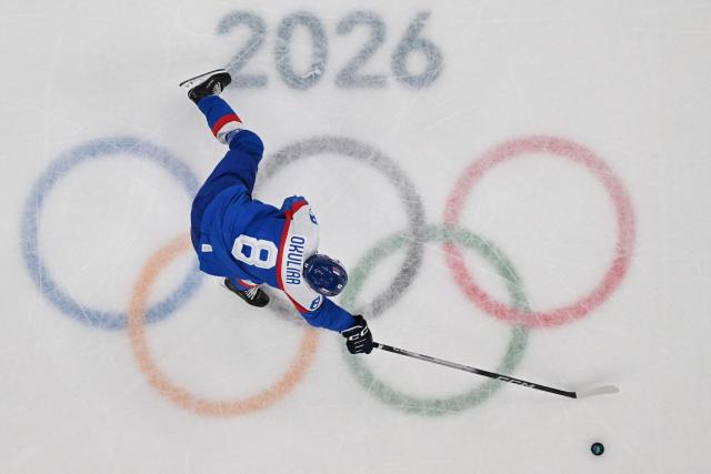 Slovakia's #08 Oliver Okuliar skates with the puck over the event logo during the men's play-off semi-final ice hockey match between USA and Slovakia at the Milano Santagiulia Ice Hockey Arena during the Milano Cortina 2026 Winter Olympic Games in Milan, on February 20, 2026. (Photo by Antonin THUILLIER / POOL / AFP)