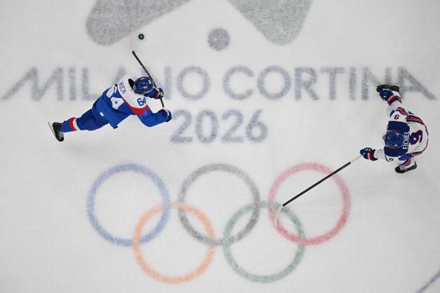 Slovakia's #64 Patrik Koch (L) fights for the puck with USA's #09 Jack Eichel  during the men's play-off semi-final ice hockey match between USA and Slovakia at the Milano Santagiulia Ice Hockey Arena during the Milano Cortina 2026 Winter Olympic Games in Milan, on February 20, 2026. (Photo by Antonin THUILLIER / AFP)