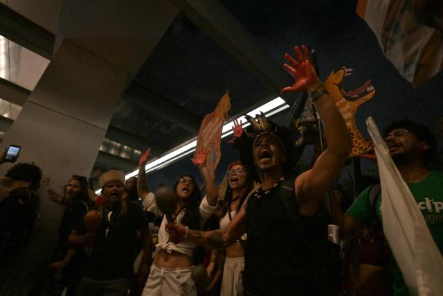 Brazilian natives from the Guarani ethnic group and environmental activists protest against dredging in the Amazon in front of the headquarters of US agribusiness giant Cargill in Sao Paulo, Brazil, on February 20, 2026. (Photo by NELSON ALMEIDA / AFP)