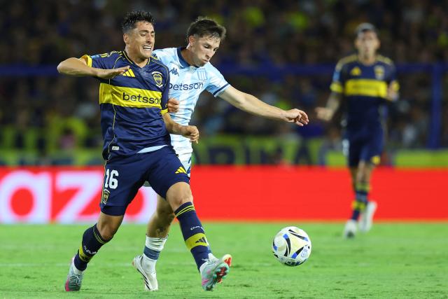 Boca Juniors' Uruguayan forward #16 Miguel Merentiel and Racing's midfielder #20 Baltasar Rodriguez fight for the ball during the Argentine Professional Football League 2026 Apertura Tournament match between Boca Juniors and Racing at La Bombonera Stadium in Buenos Aires on February 20, 2026. (Photo by Alejandro PAGNI / AFP)