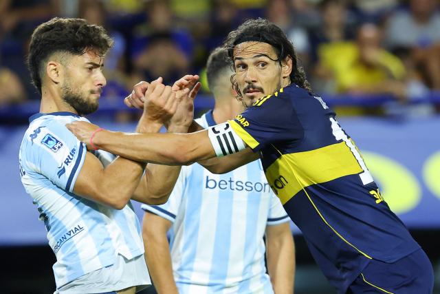 Boca Juniors' Uruguayan forward #10 Edinson Cavani pushes Racing's defender #03 Marco Di Cesare during the Argentine Professional Football League 2026 Apertura Tournament match between Boca Juniors and Racing at La Bombonera Stadium in Buenos Aires on February 20, 2026. (Photo by Alejandro PAGNI / AFP)